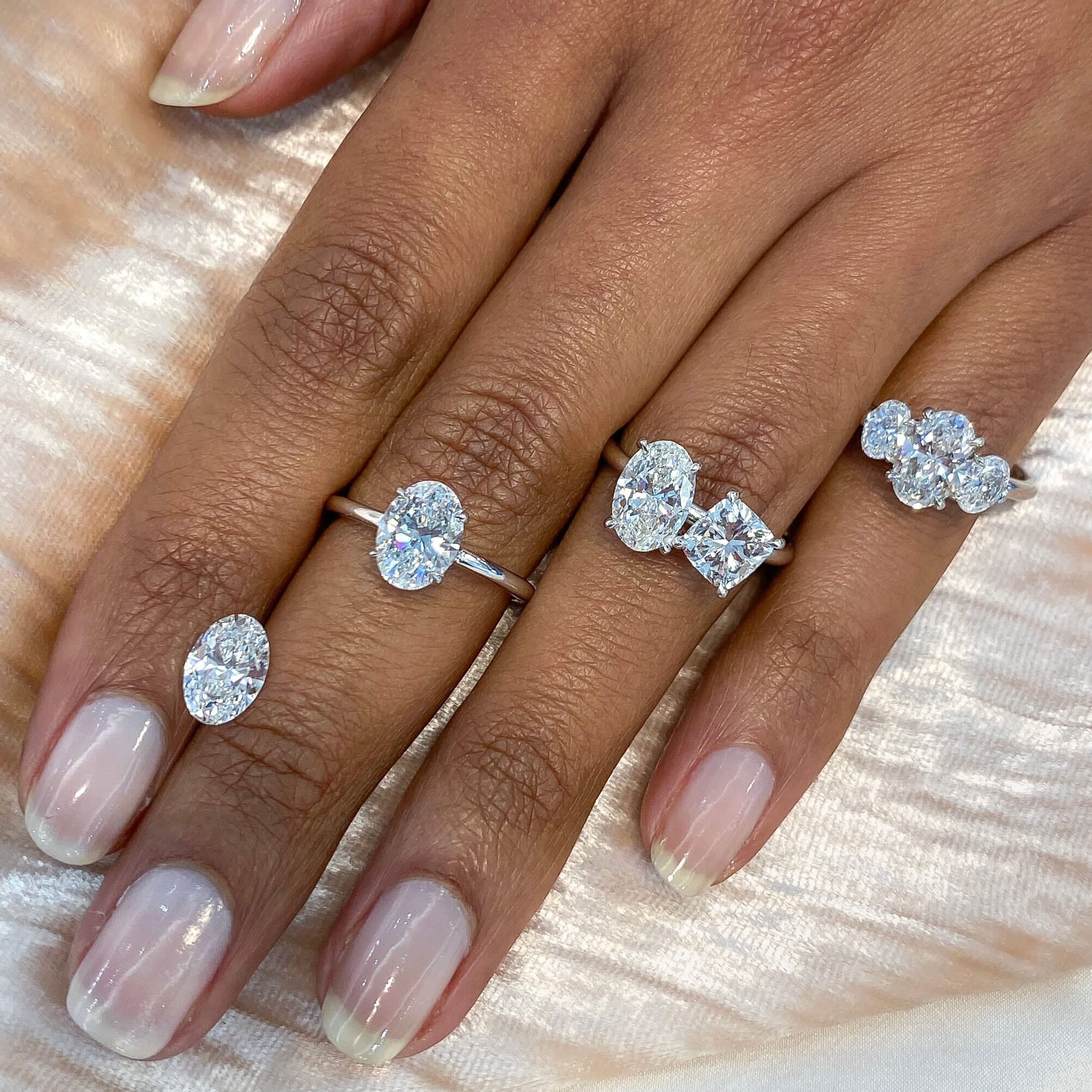 four various engagement ring styles on ladies hand